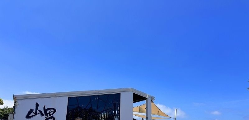 山男咖啡 藍天下的純白外牆與山男書法招牌實拍