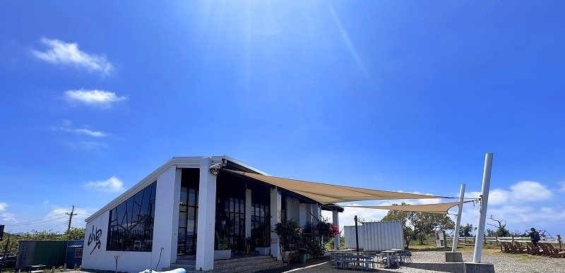 山男咖啡 碎石庭園、藍牛雕塑與白色建築側面實拍