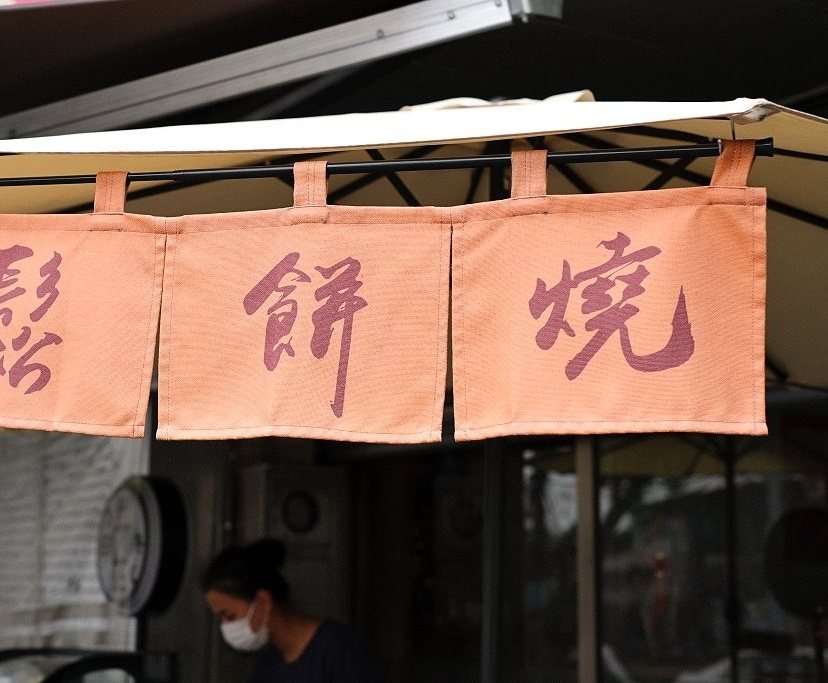 艸止日央 製餅舖 橘色門簾上手寫的鬆餅燒招牌