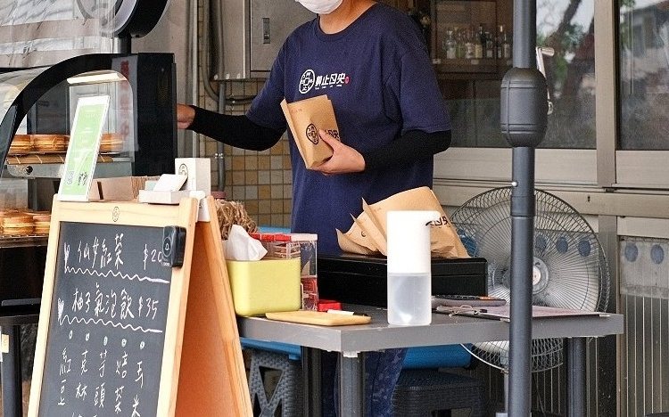艸止日央 製餅舖 老闆娘在攤車前現點現做、細心包裝鬆餅燒