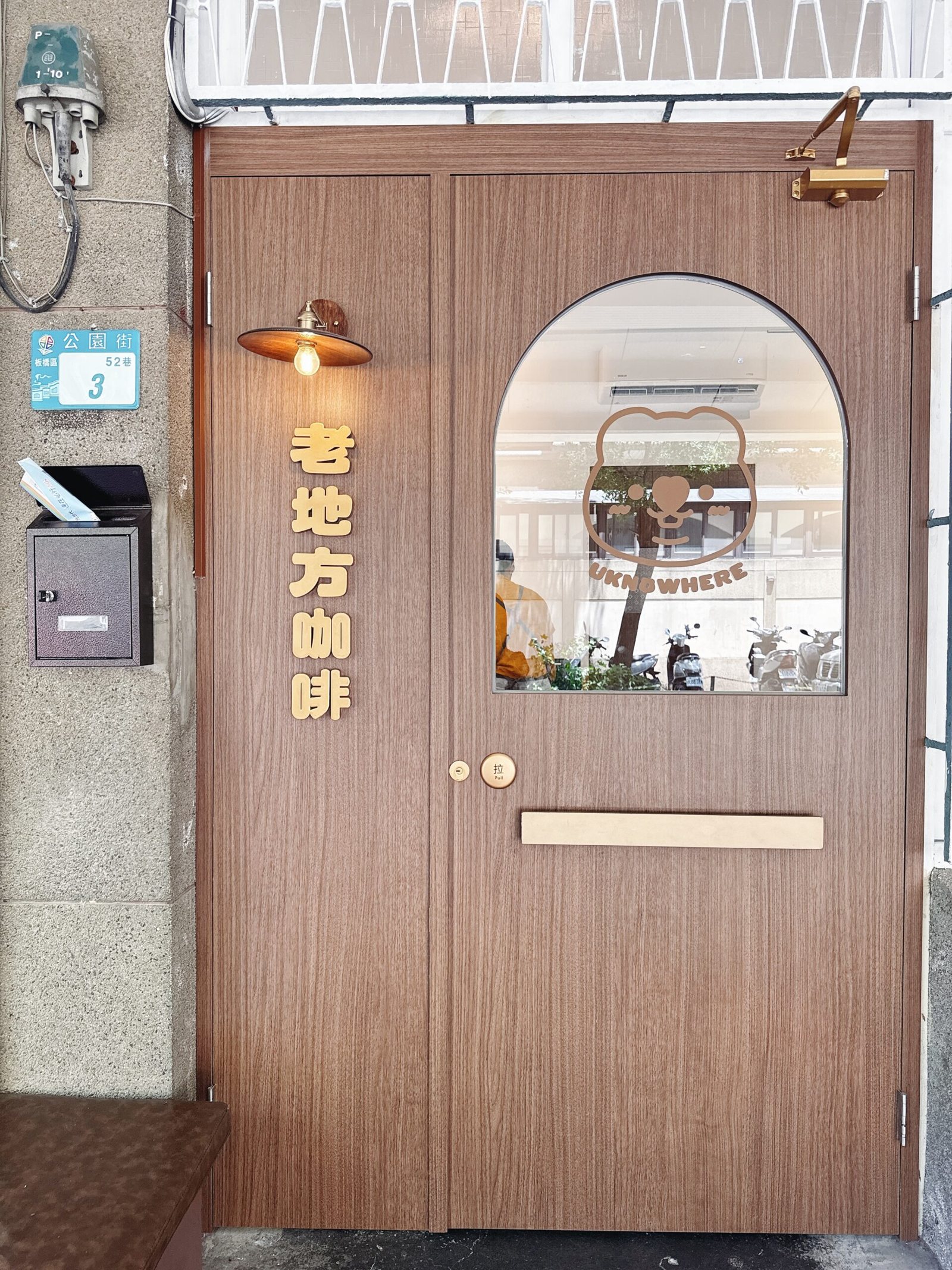 哩哉咖啡 老宅木門與招牌熊熊 LOGO 入口（取自公開報導）
